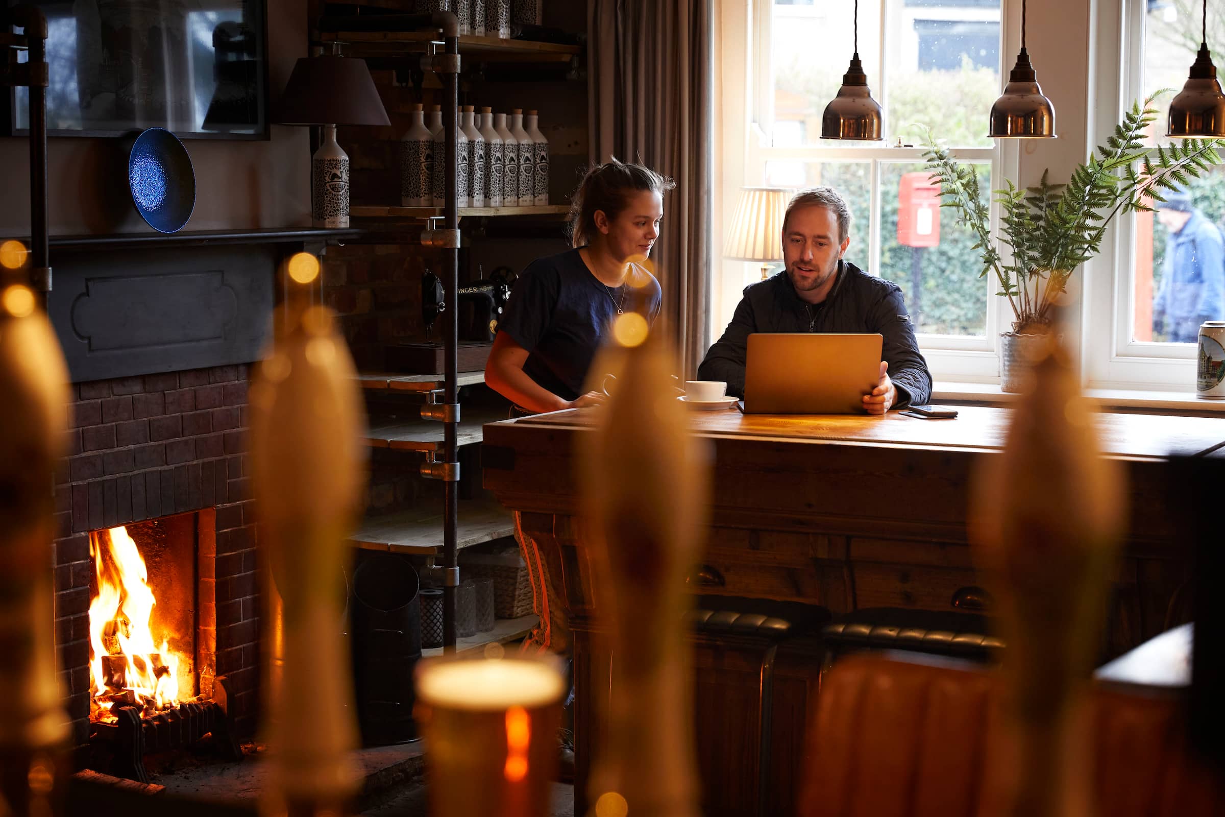 Two bar owners sitting at a desk with a laptop using Xero accounting software.