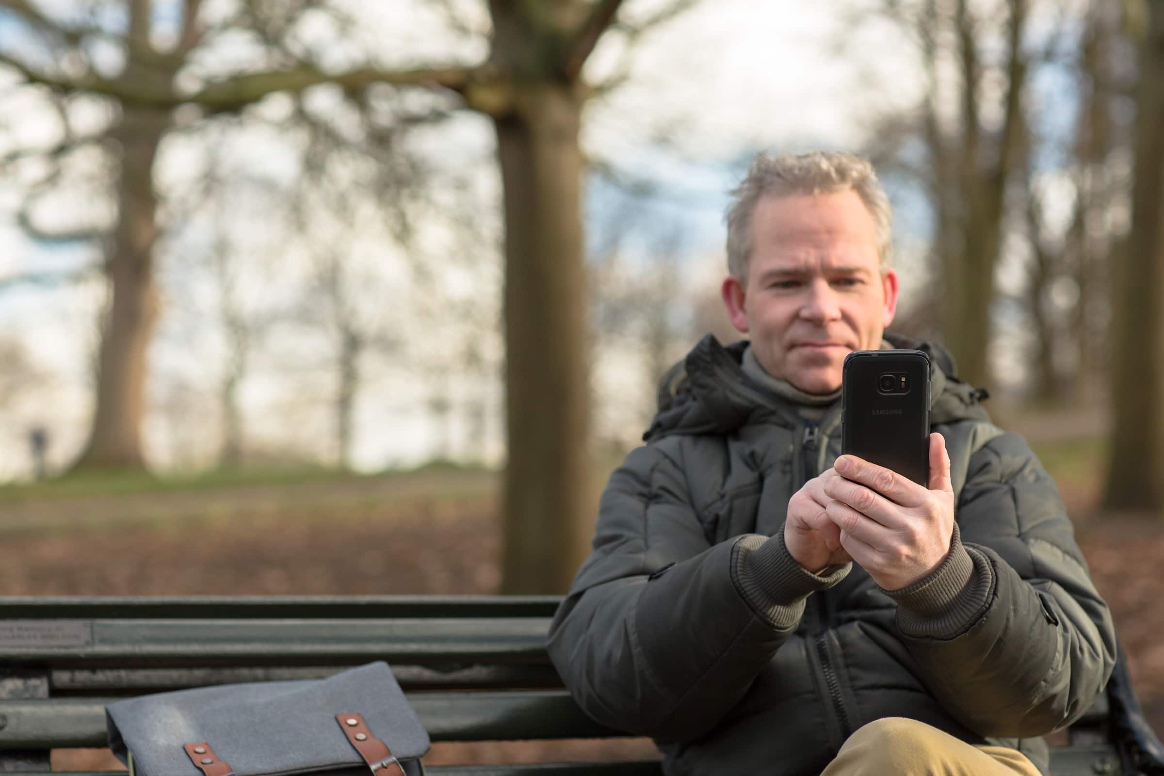 An owner of a landscaping company using Xero accounting software on their mobile.