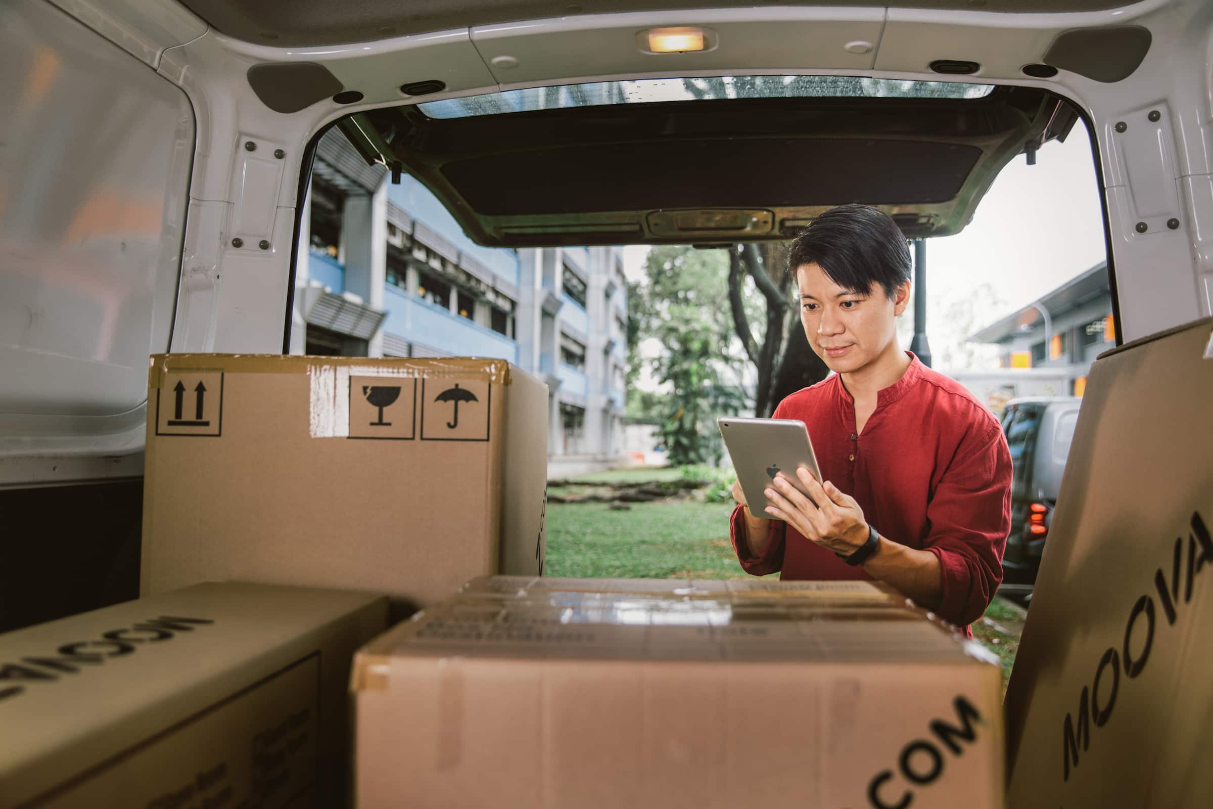 A moving business owner using Xero's accounting software while looking into the back of their moving van.