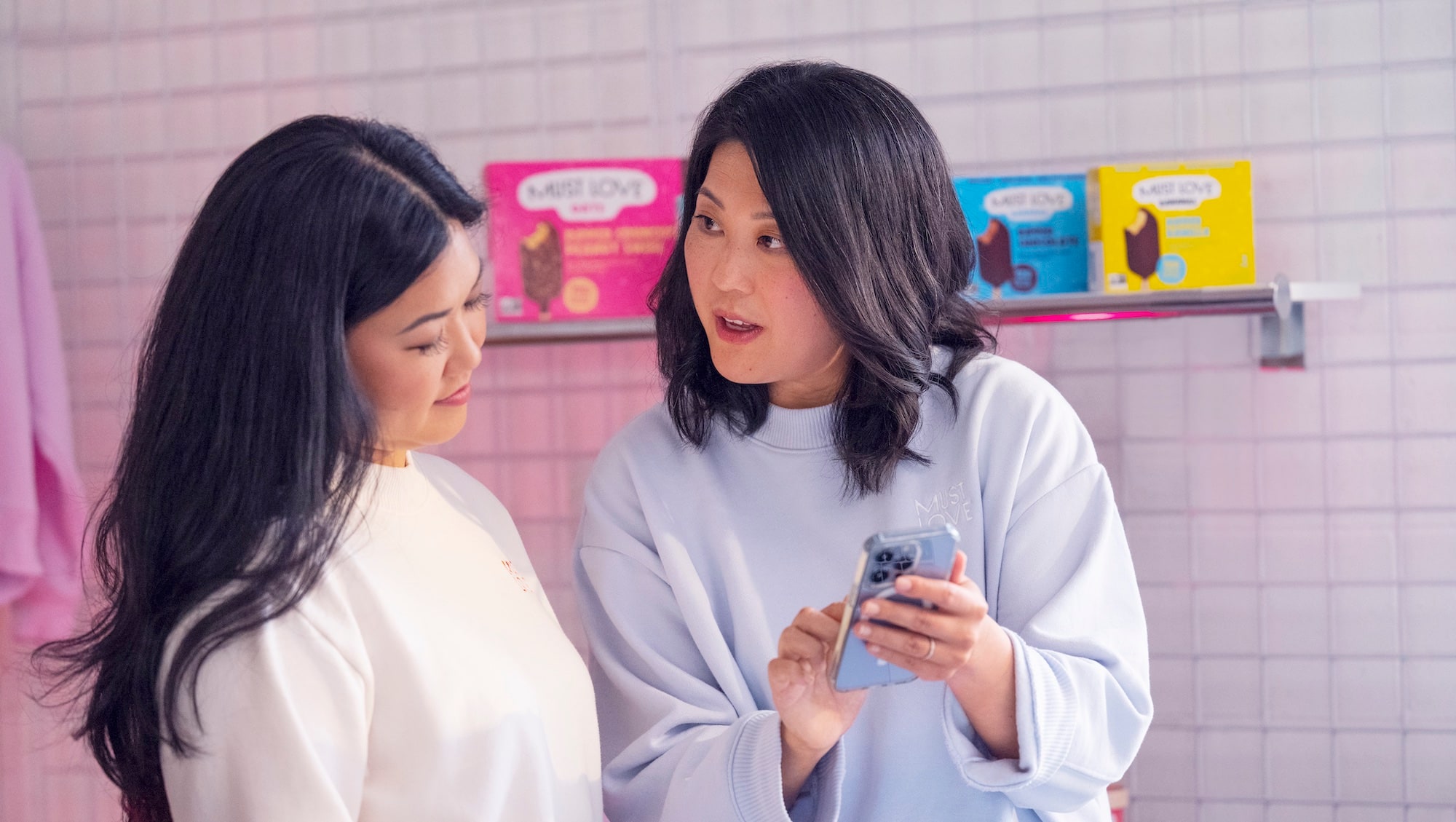 Hannah and Mollie from Must Love looking at a phone