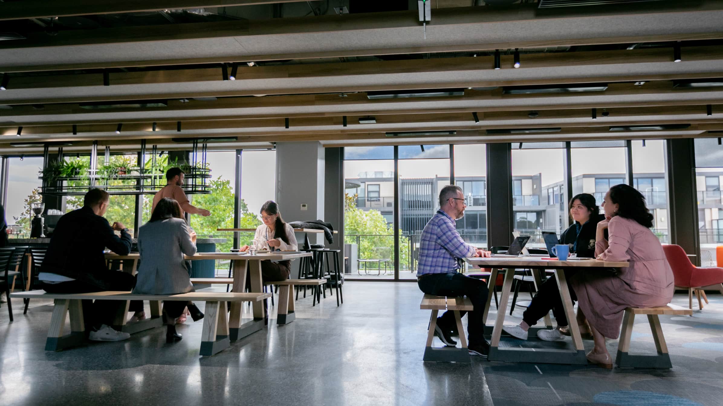 Groups of Xero employees work together in an informal meeting space.