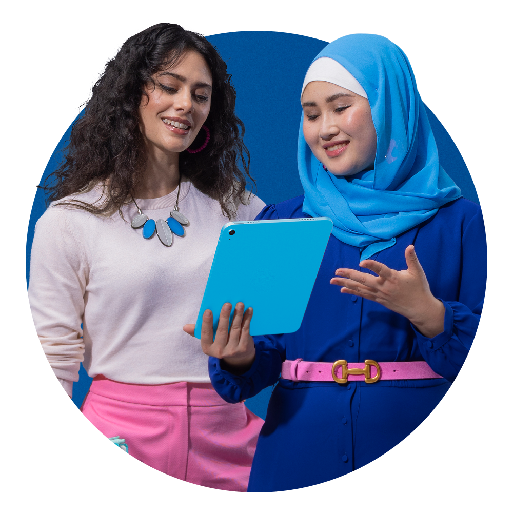 Two women stand reading a Xero accountant bookkeeper guide on a tablet. 