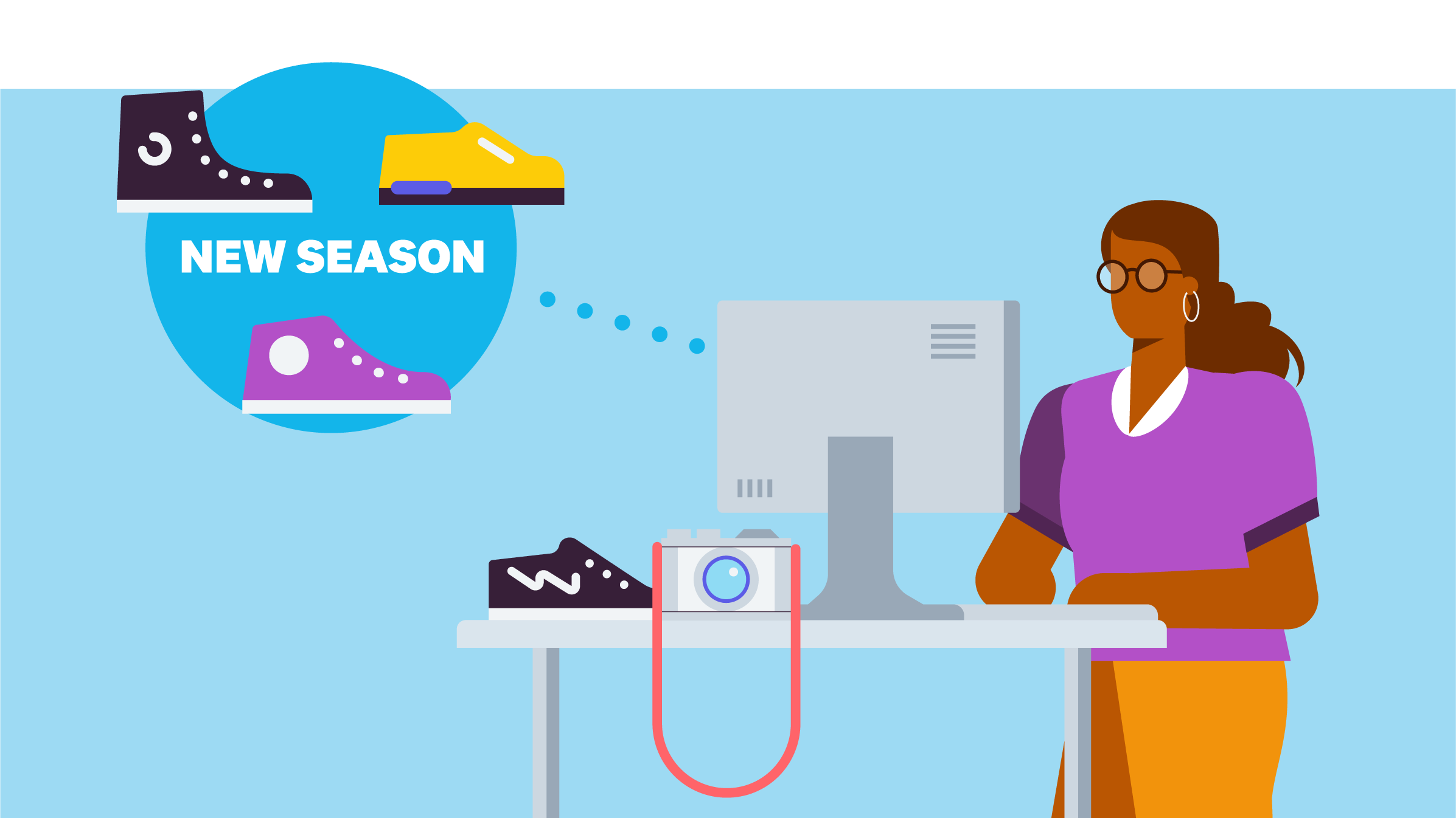 A clothing business owner standing at a desk while using a computer.